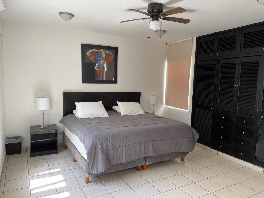 a bedroom with a bed and a ceiling fan at Casa Mel, Excelente ubicacion, seguridad in Cozumel