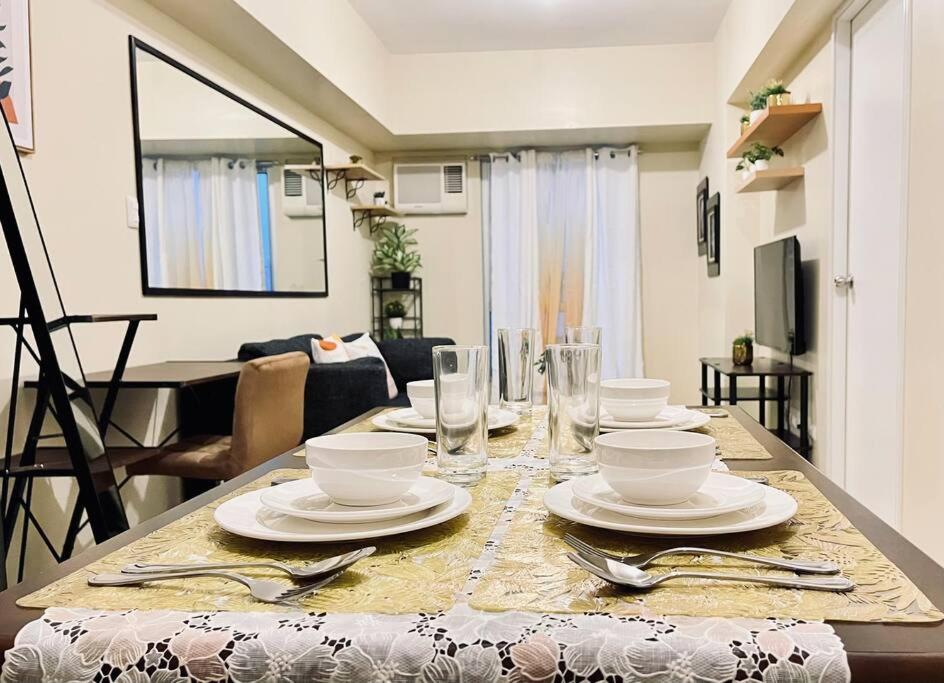 a dining room table with plates and silverware on it at Modern Comfort at Avida Riala in Cebu City