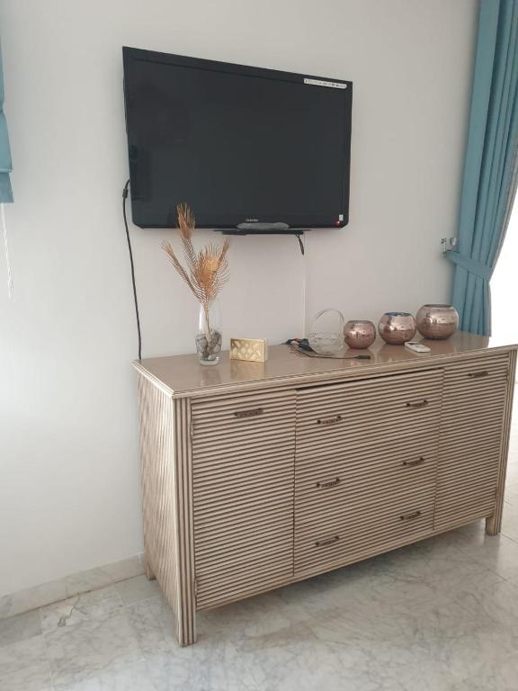 a flat screen tv on top of a wooden cabinet at Two bedrooms appart in the heart of sousse in Sousse
