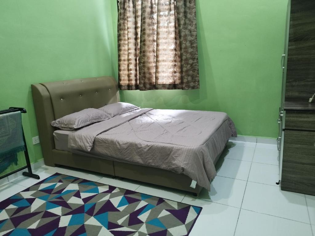 a bedroom with a bed and a colorful floor at Nurul Homestay in Kepala Batas