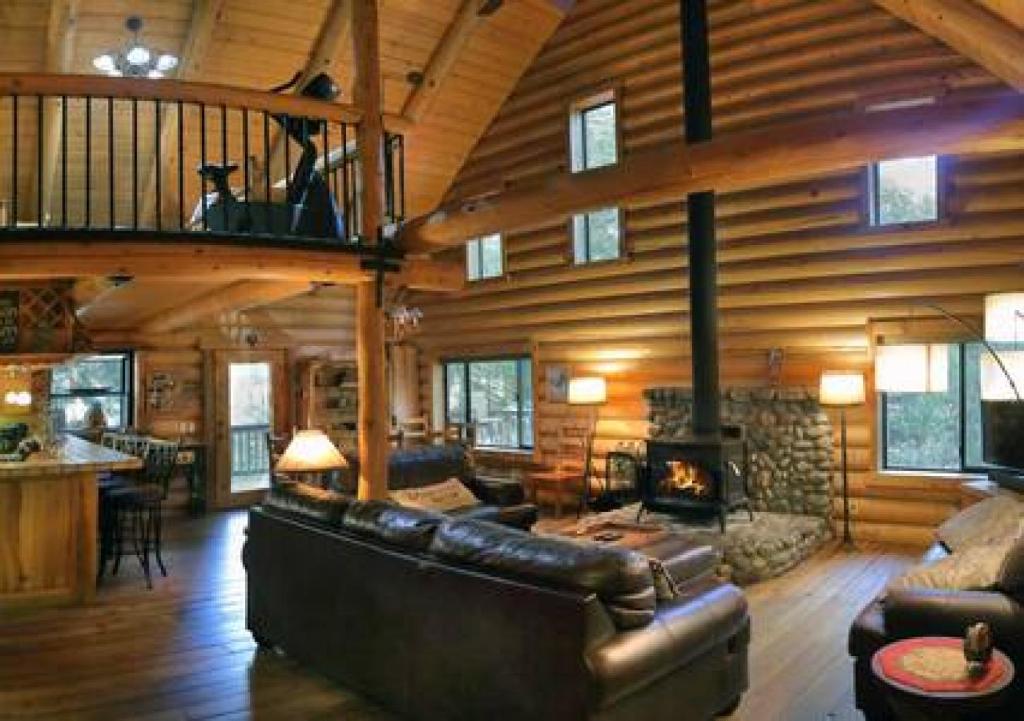sala de estar con sofá y chimenea en Eagles Nest - Natural Log Cabin with Guest House, en Idyllwild