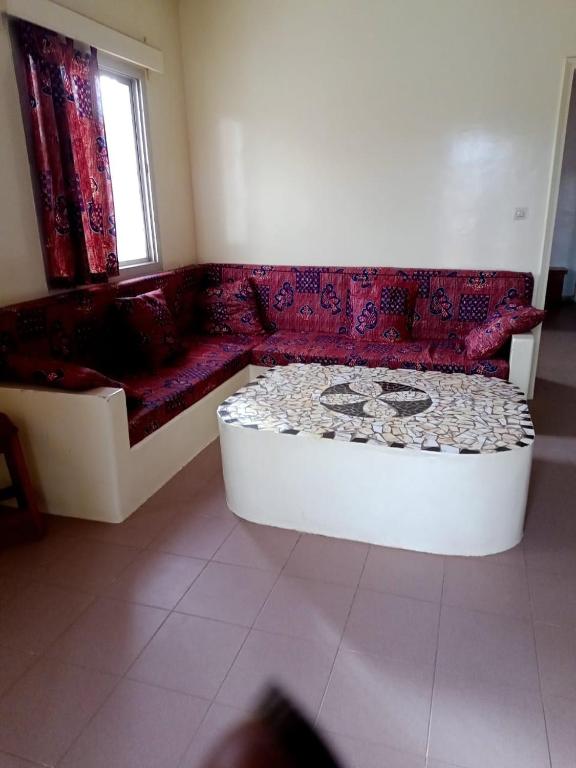 a living room with a red couch and a window at Villa duchesse in Sali Nianiaral