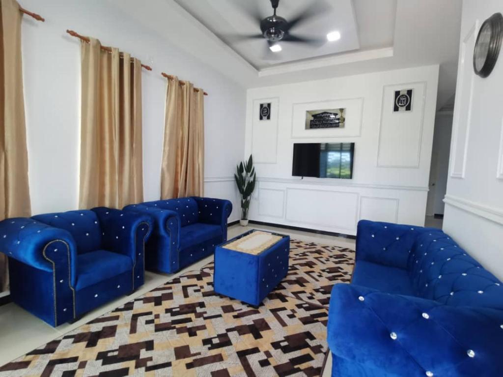 un soggiorno con divani blu e TV di Sunshine Homestay a Kuala Terengganu