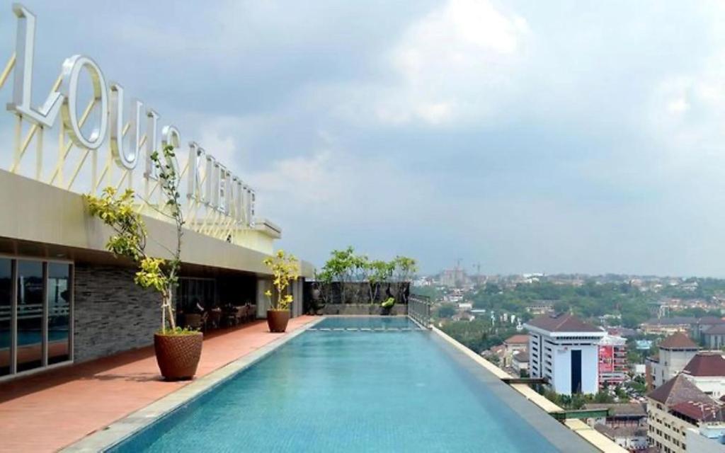a swimming pool on the roof of a building at Channel Stay Warhol Simpang Lima Semarang in Semarang