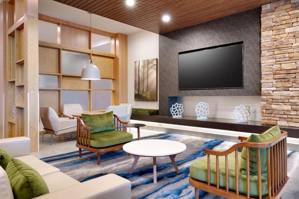 sala de estar con sofá, sillas y TV en Fairfield Inn & Suites by Marriott Houston League City, en League City