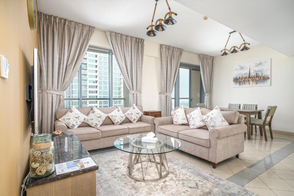 a living room with two couches and a table at ALH Vacay - 2 bedrooms Apartment in Golf Towers 1 in Dubai