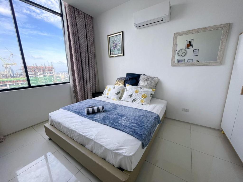 ein Schlafzimmer mit einem Bett und einem großen Fenster in der Unterkunft Cebu Aviner(water Front) in Cebu City