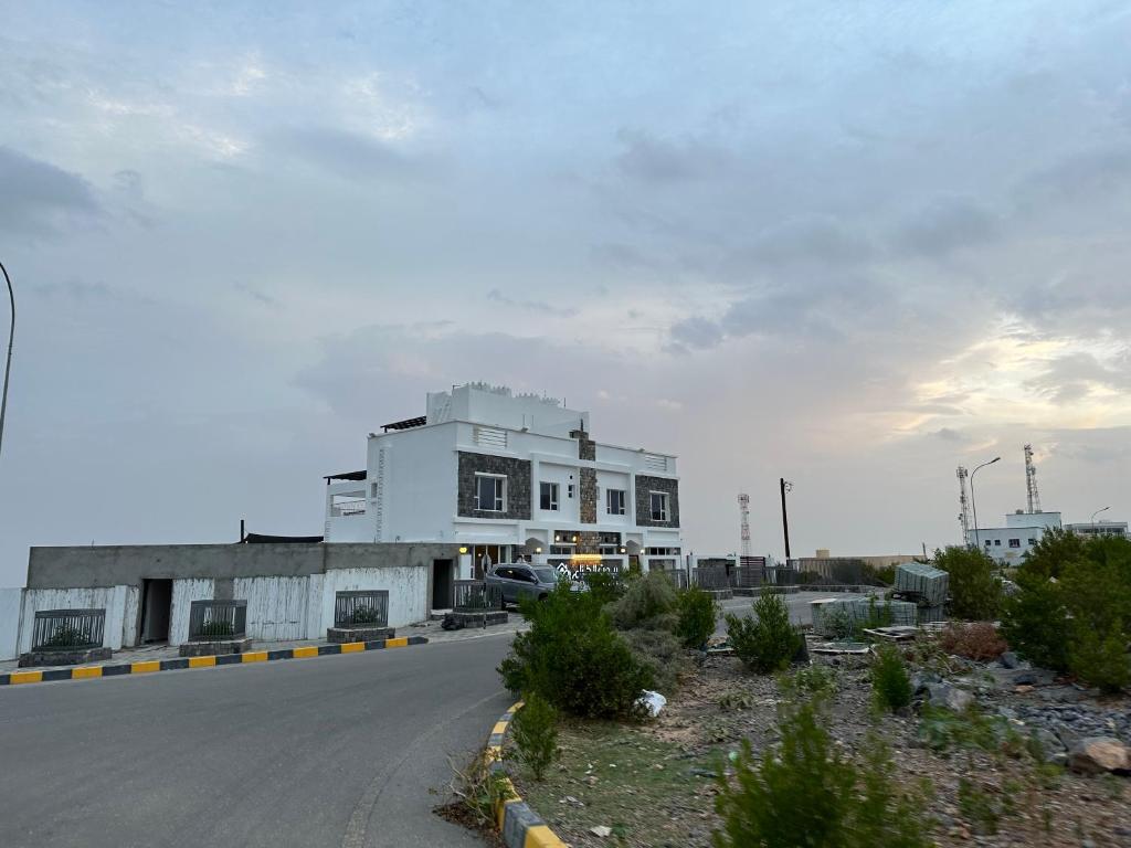 a large white building on the side of a road at بيوت الخزام in Salmah
