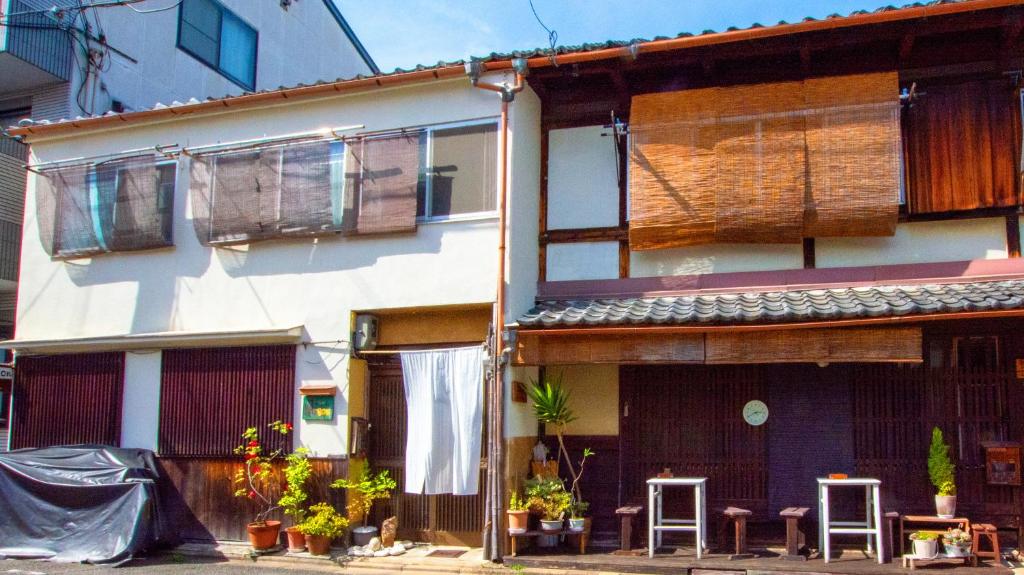 a house with two stools in front of it at Guesthouse Bon in Kyoto