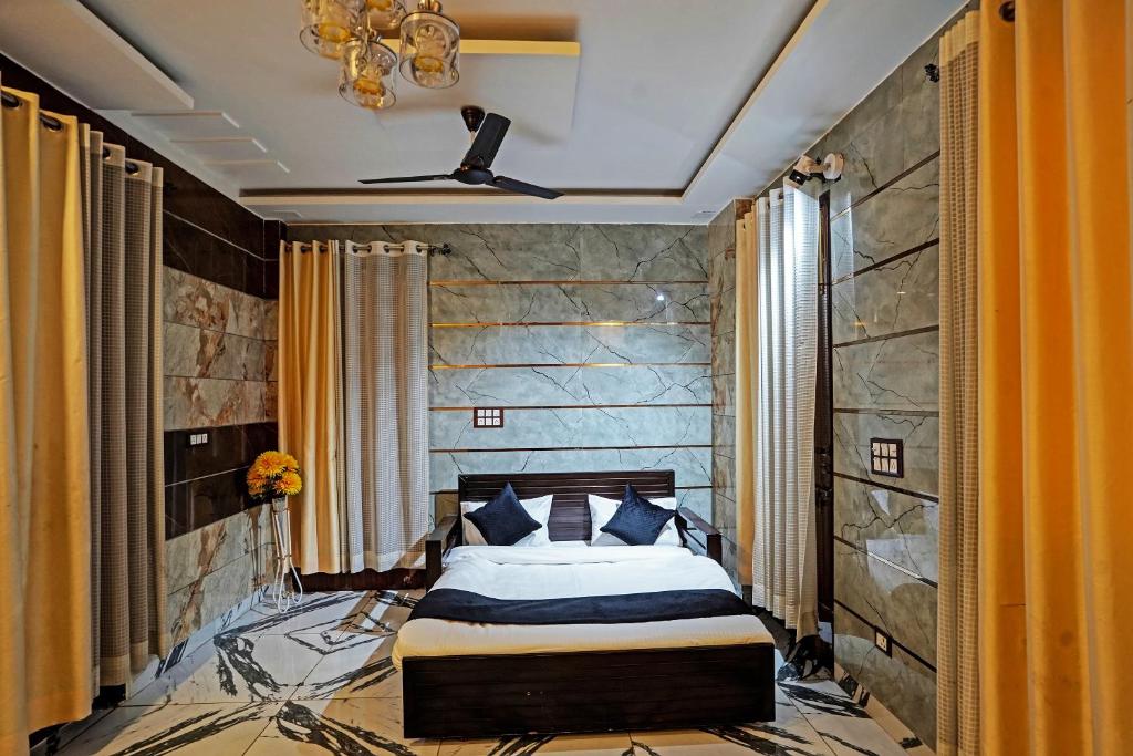 een slaapkamer met een bed en een stenen muur bij HOTEL PLATINUM Noida 144 in Noida