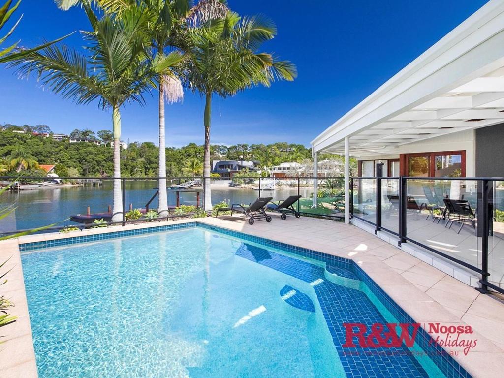 a swimming pool in a house with a view of the water at 19 Wesley Court, Noosa Heads in Noosa Heads