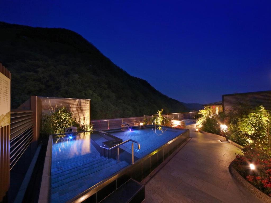 une piscine sur le toit d'un bâtiment la nuit dans l'établissement Asaya, à Nikkō