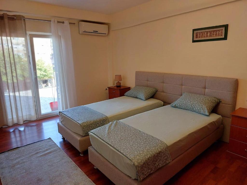 a bedroom with two beds and a couch and a window at Solaris Guest House in Shkodër