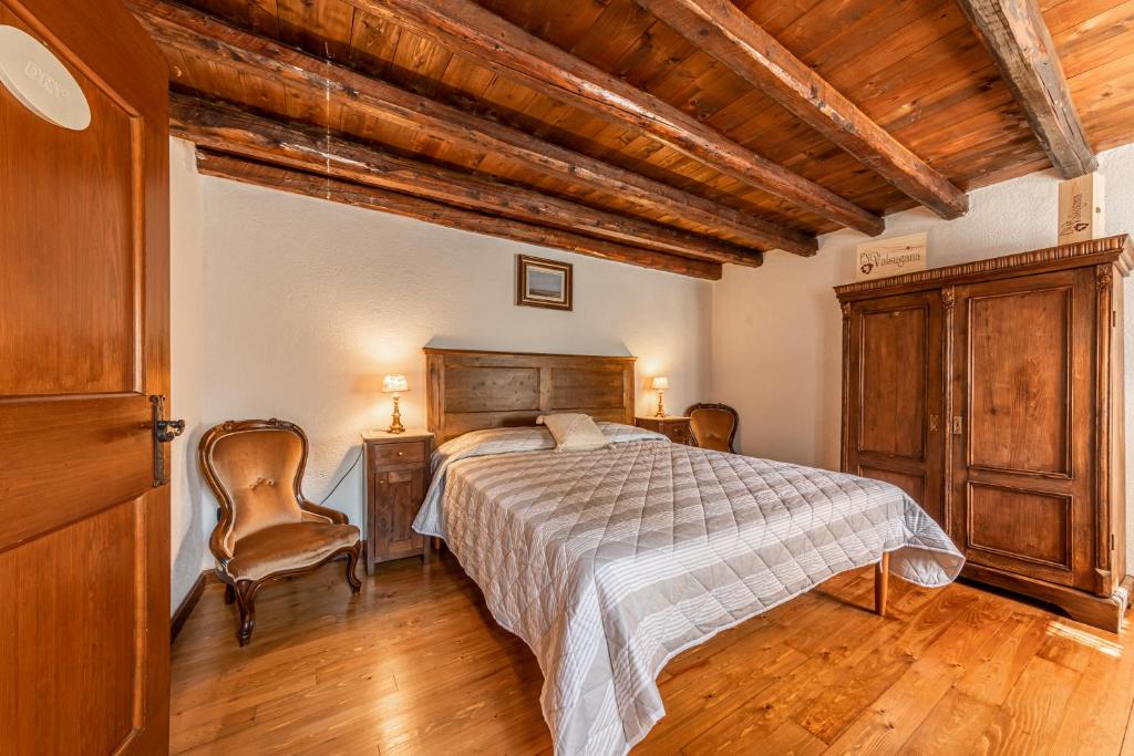 een slaapkamer met een bed en een houten plafond bij GuestHouse Baldi: The Perfect Refuge between Vineyards and Nature in Ogliano