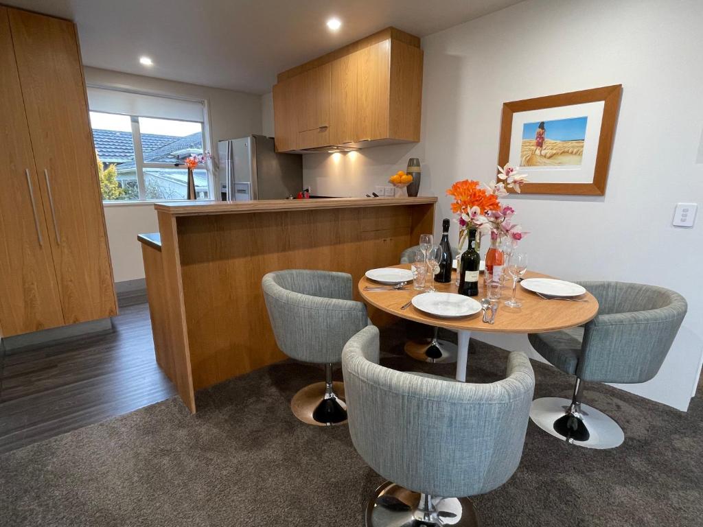 una cucina con tavolo, sedie e bancone di Plymouth Central City 2 Bedroom Apartments a New Plymouth