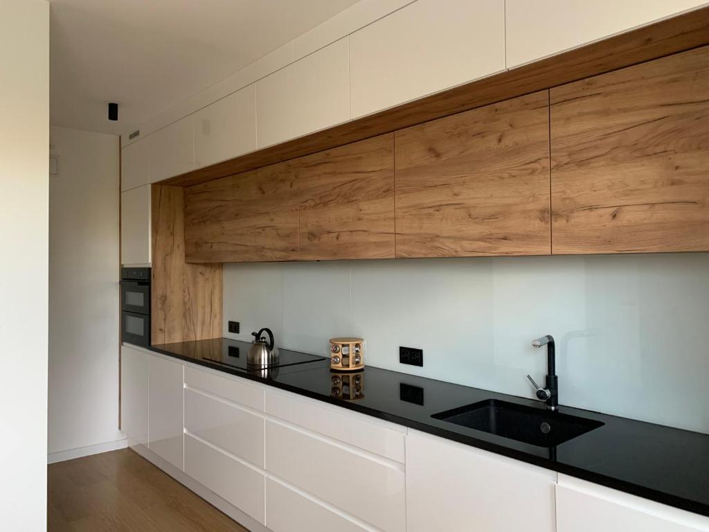 a kitchen with white cabinets and a black counter top at Dunajec Home 