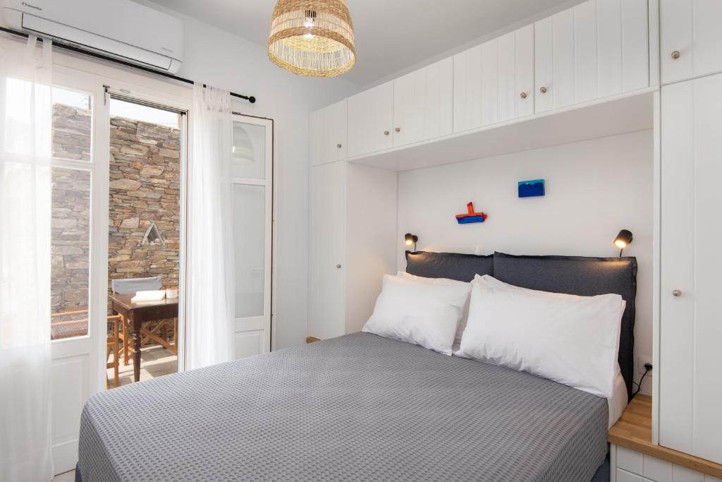 a bedroom with a bed with white walls and a window at Apelagitis 1 in Exámbela