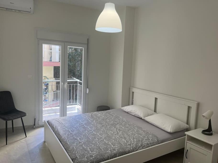 ein weißes Schlafzimmer mit einem Bett und einem Fenster in der Unterkunft Amazing apartment in the center in Thessaloniki