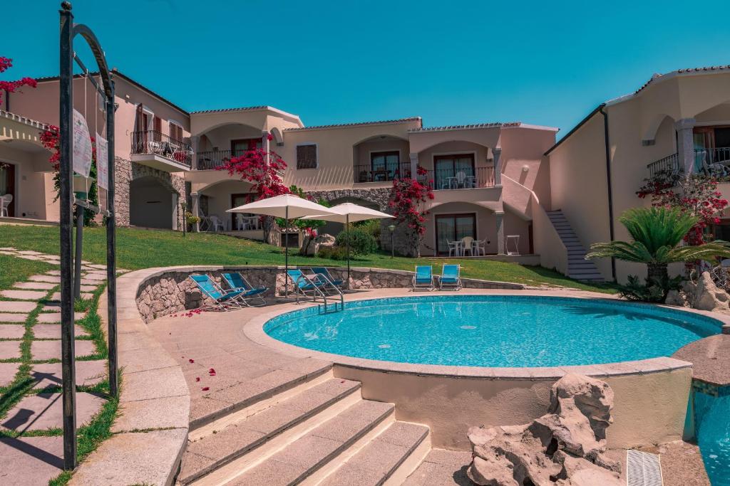 a swimming pool in front of a building at ISA-Residence with swimming-pool in Badesi, apartments with air conditioning and private outdoor space in Badesi