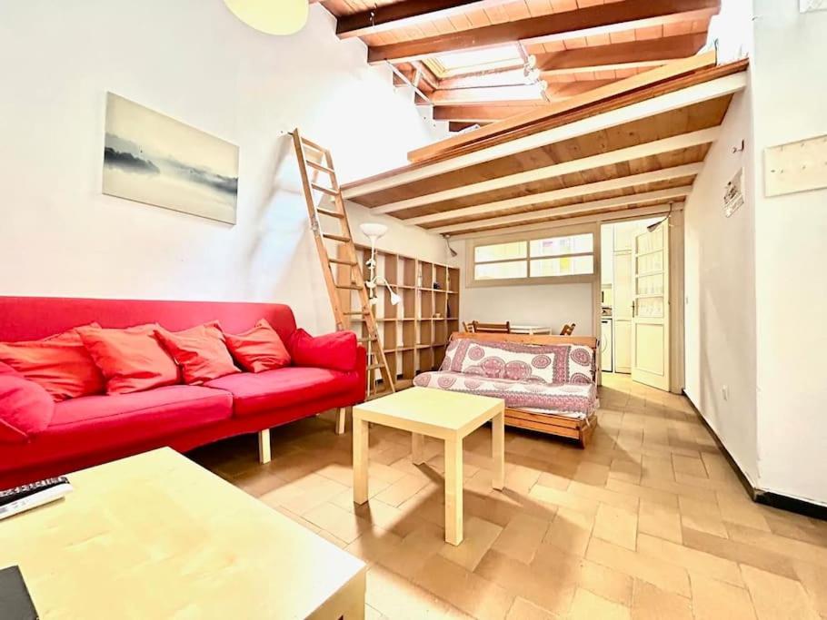 sala de estar con sofá rojo y escalera en Hispalis mercado de Triana, en Sevilla