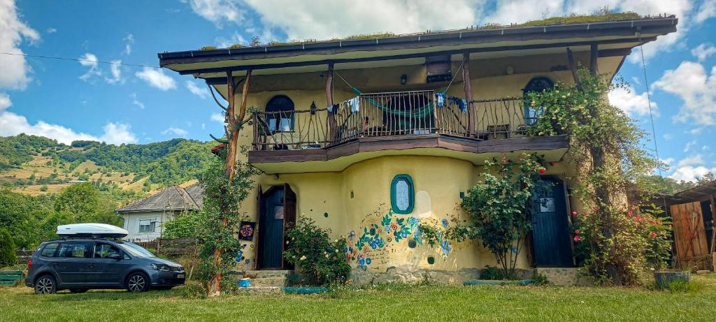 a car parked in front of a house with a balcony at Popasul Verde in Sîngeorz-Băi