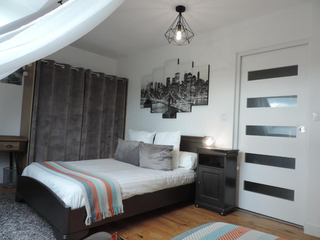 1 dormitorio con 1 cama y una foto en la pared en Relais Du Boss, en Saint-Vran