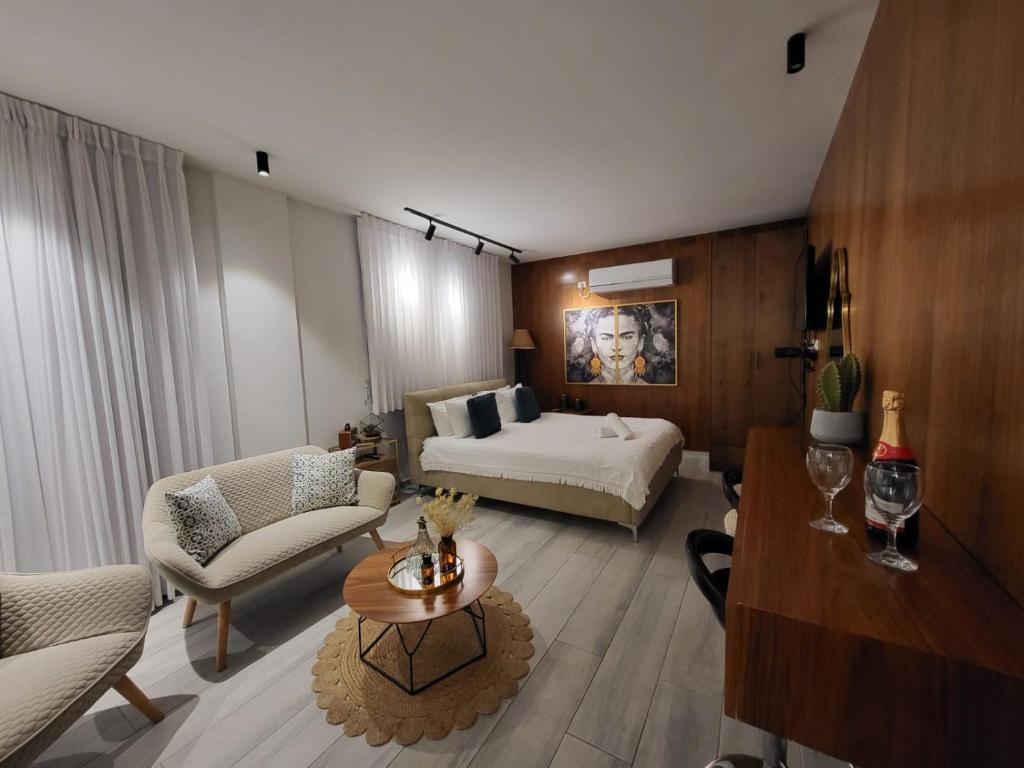 ein großes Wohnzimmer mit einem Bett und einem Tisch in der Unterkunft צימר בוטיק אדלה Zimmer boutique adela in Arad