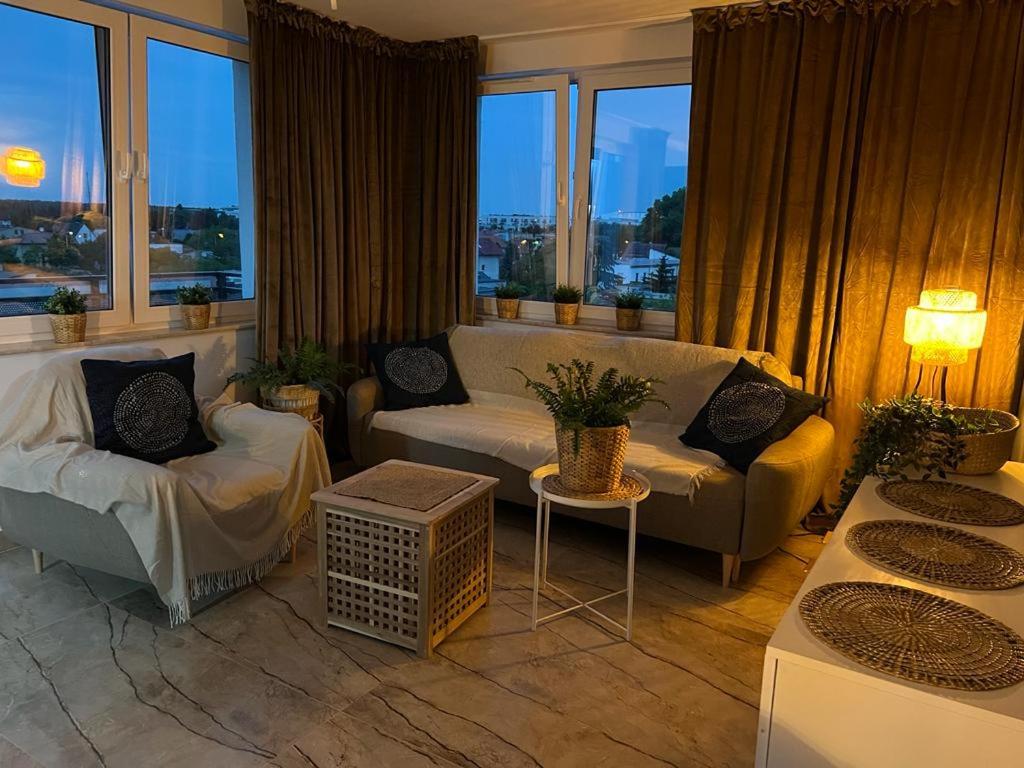 a living room with two couches and a large window at Apartament BOHO na Ziębickiej Parking in Poznań