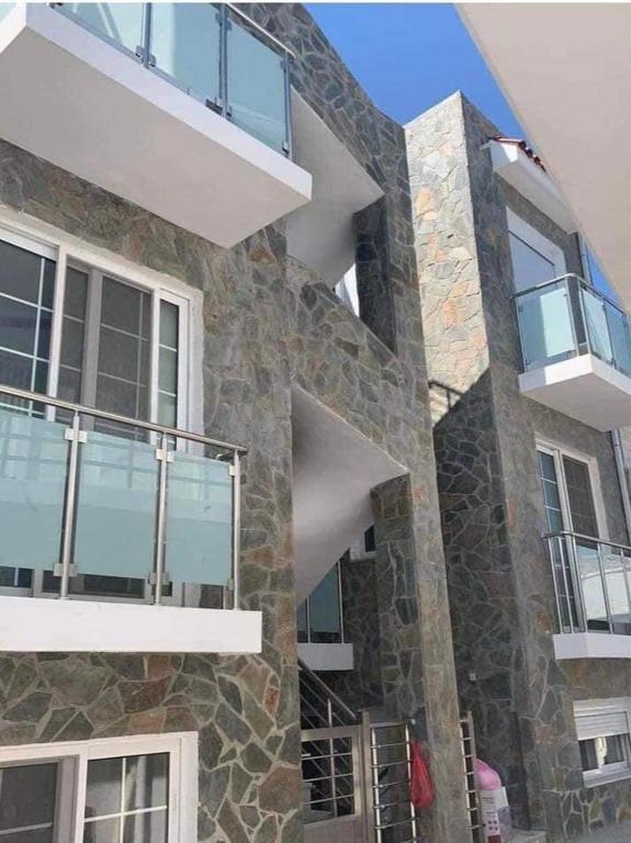 a stone building with balconies on the side of it at Despinas Seafront Apartments,Haraki in Haraki