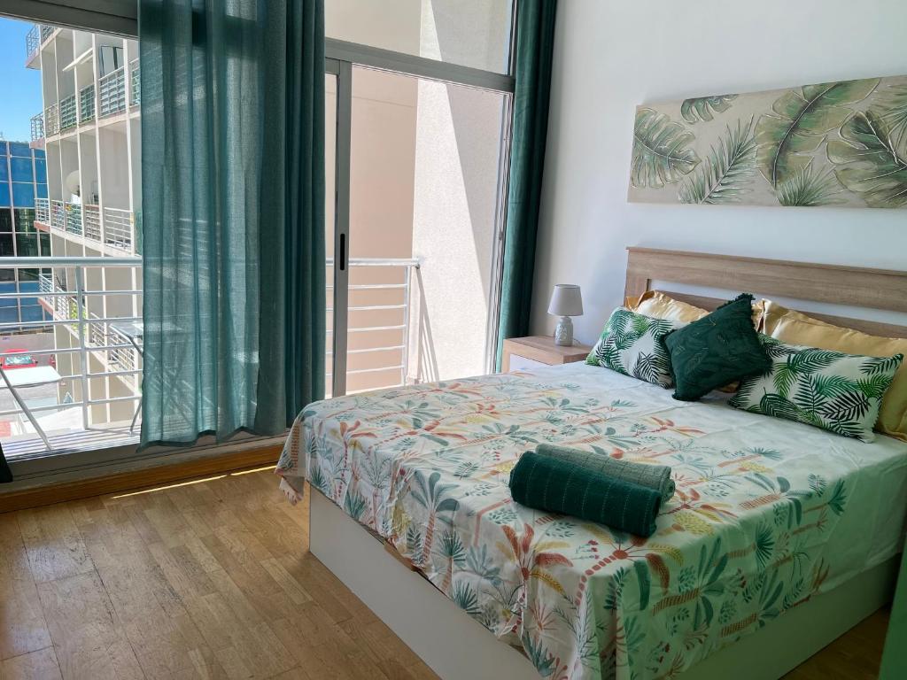 Aparment sierra Guadalupe في مدريد: غرفة نوم بسرير ونافذة كبيرة