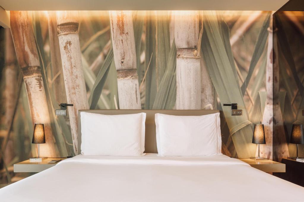 a bed with two white pillows in a room at Saccharum - Resort and Spa - Savoy Signature in Calheta