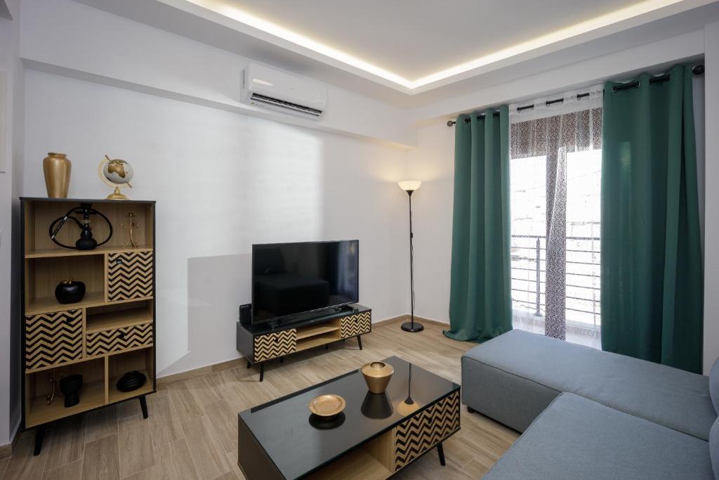 a living room with a couch and a tv at Pap's Lab Apartments in Heraklio
