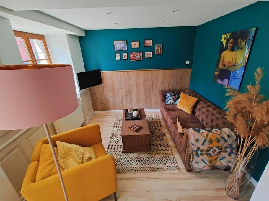 uma sala de estar com um sofá e uma mesa em Maison au cœur des vignobles em Westhoffen