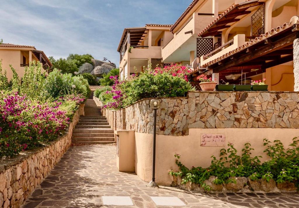 a house with flowers on the side of it at ISA-Residence in Marinella at only 450 m from the beach, apartments with air conditioning in Marinella