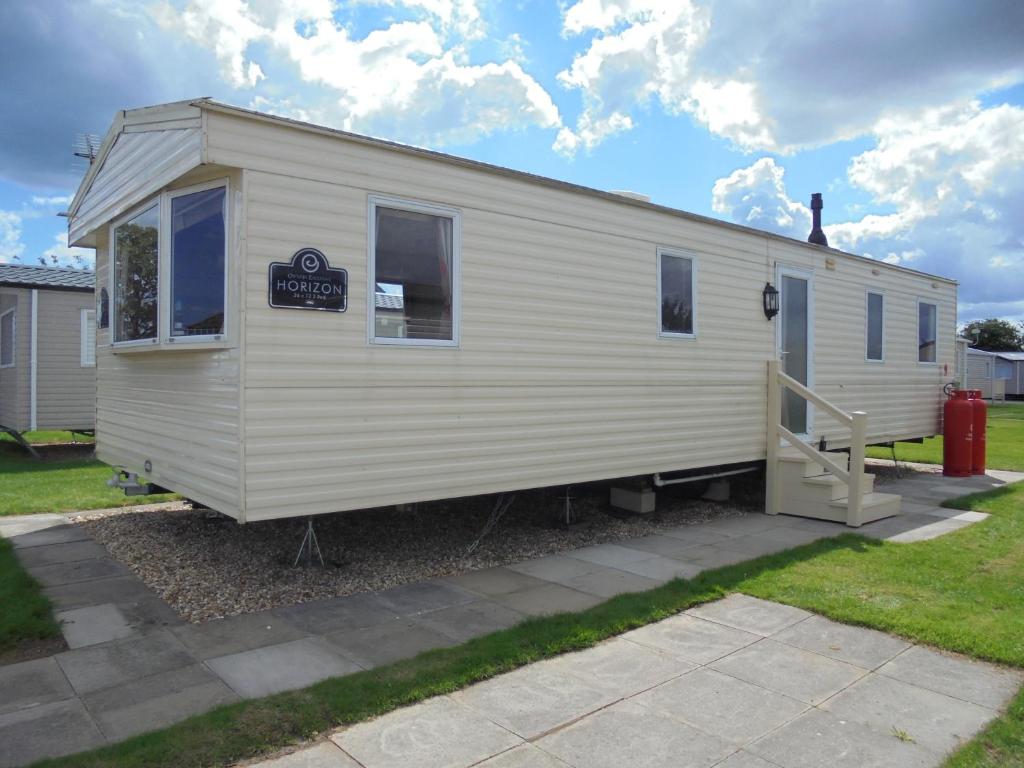 a white tiny house with a sign on it at Kingfisher : Horizon II:- 8 Berth, Close to site entrance in Ingoldmells