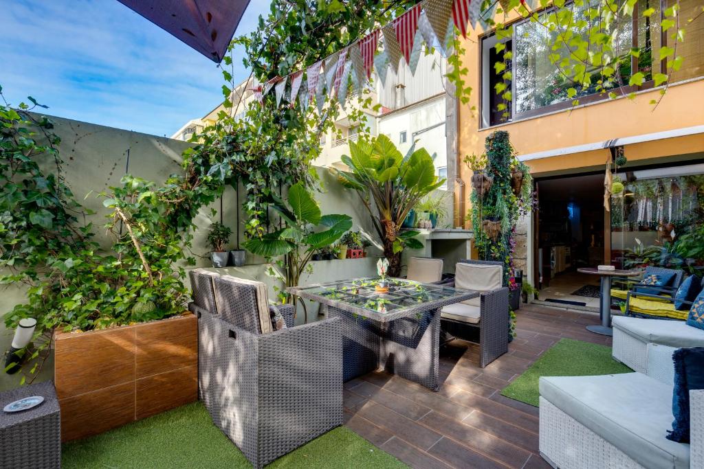 patio ze stołem, krzesłami i roślinami w obiekcie Garden in Town Hostel w Porto
