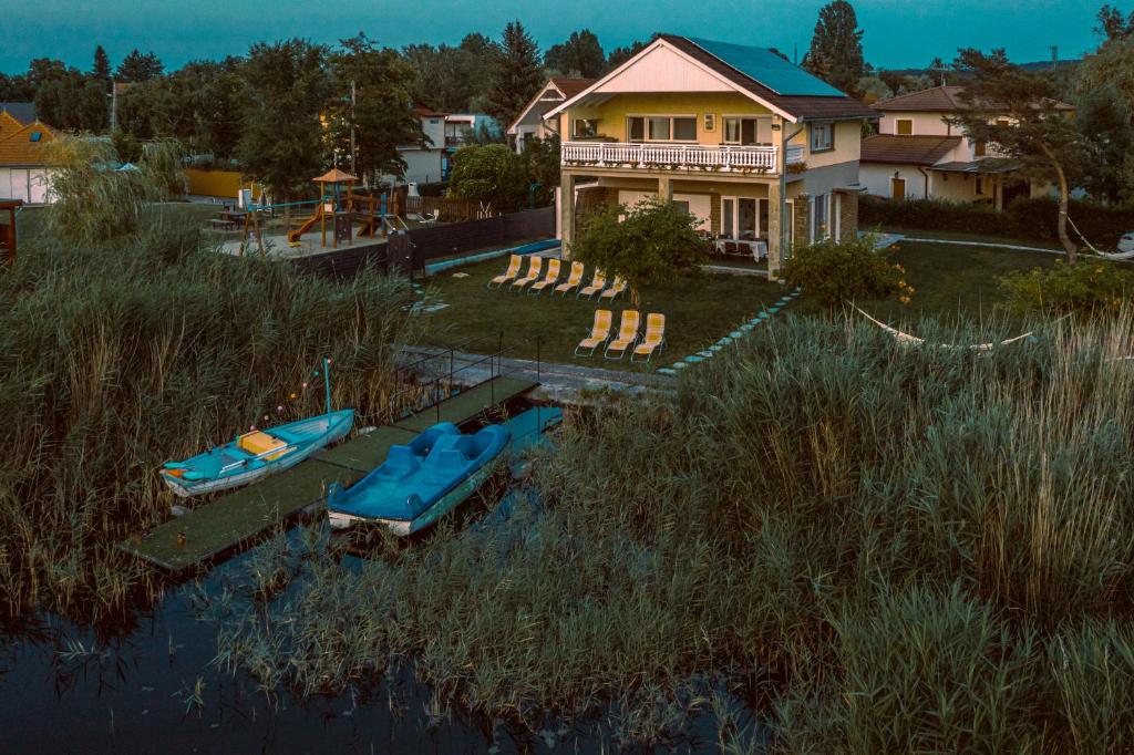 a house with two boats in the water at Sunny Beach Villa in Szántód