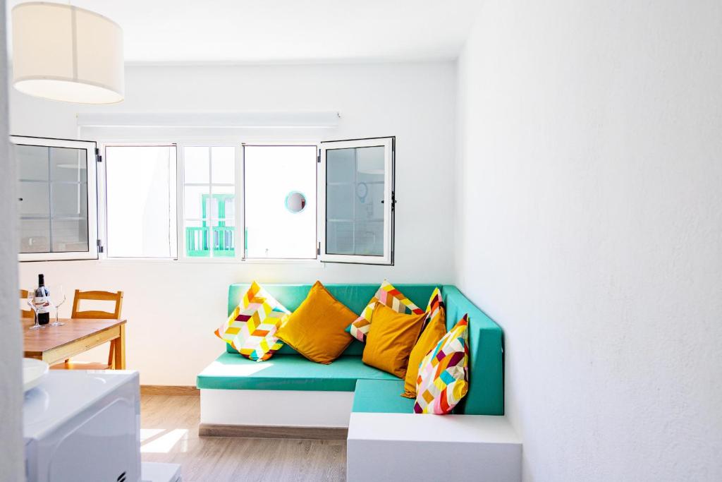 een woonkamer met een blauwe bank en kleurrijke kussens bij Maresia in Arrieta