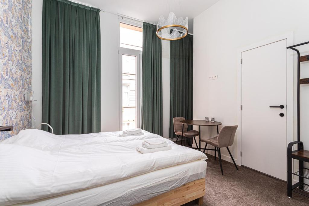 um quarto com uma cama e uma mesa com cadeiras em Studio Anvers em Antuérpia