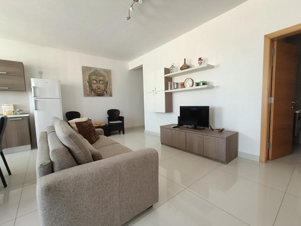 a living room with a couch and a tv at Crescent Court F in St. Paul's Bay