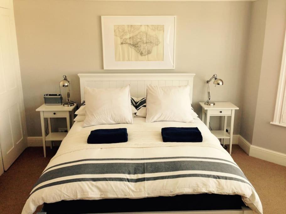 a bedroom with a large bed with two tables at Pretty coastal victorian cottage in Yarmouth IOW in Yarmouth