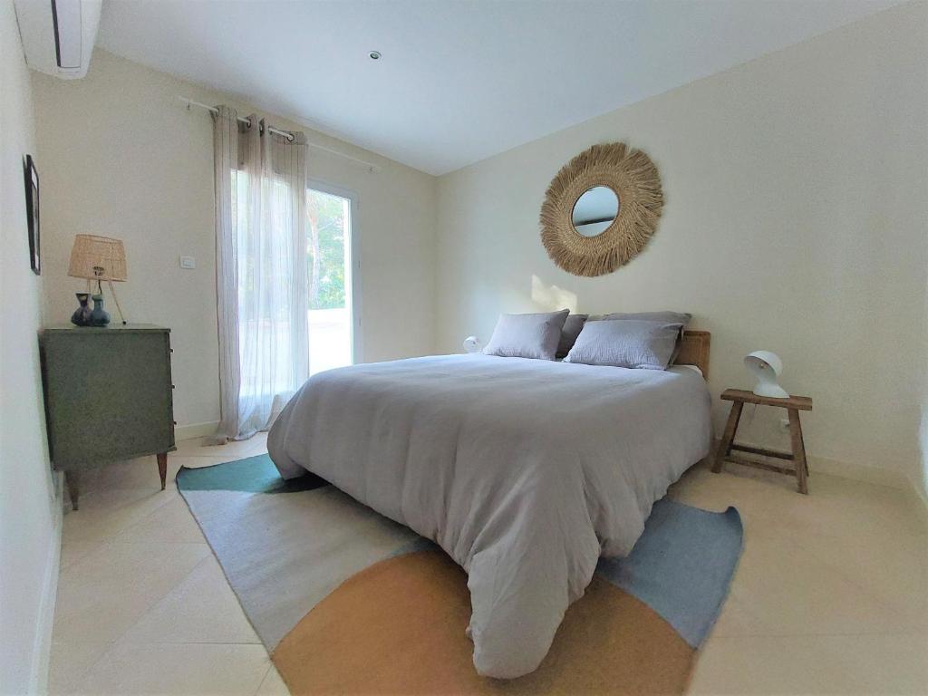 a bedroom with a large bed with a mirror on the wall at Casa des Pins - Villa d’exception à Sète in Sète