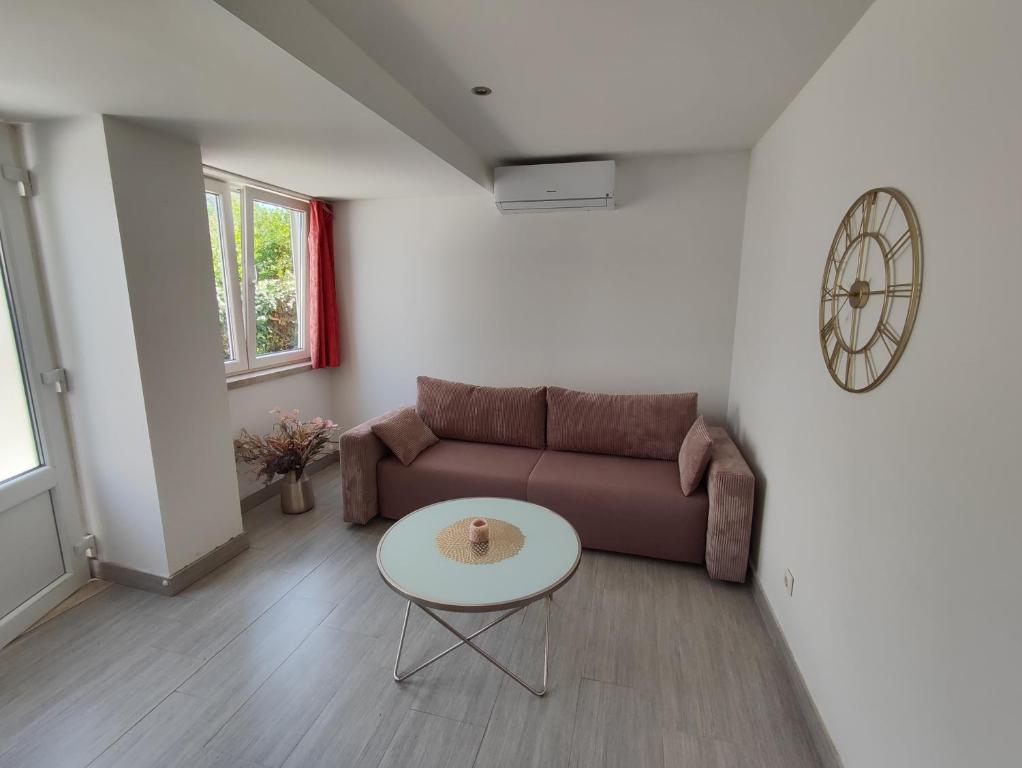 ein Wohnzimmer mit einem Sofa und einem Tisch in der Unterkunft Zorić Apartments & Rooms 2 in Dubrovnik