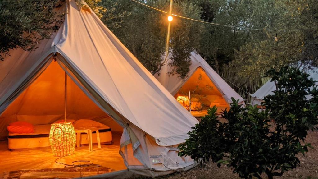 卡薩米里的住宿－Garden Lake Camping，帐篷前配有桌子和椅子