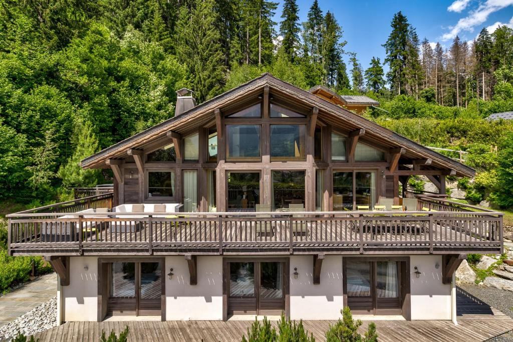 une grande maison avec une grande terrasse à l'avant dans l'établissement Chalet Le Favre, à Chamonix-Mont-Blanc