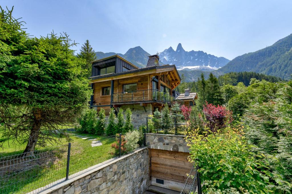 une maison en rondins avec des montagnes en arrière-plan dans l'établissement Chalet Red Fox, à Chamonix-Mont-Blanc