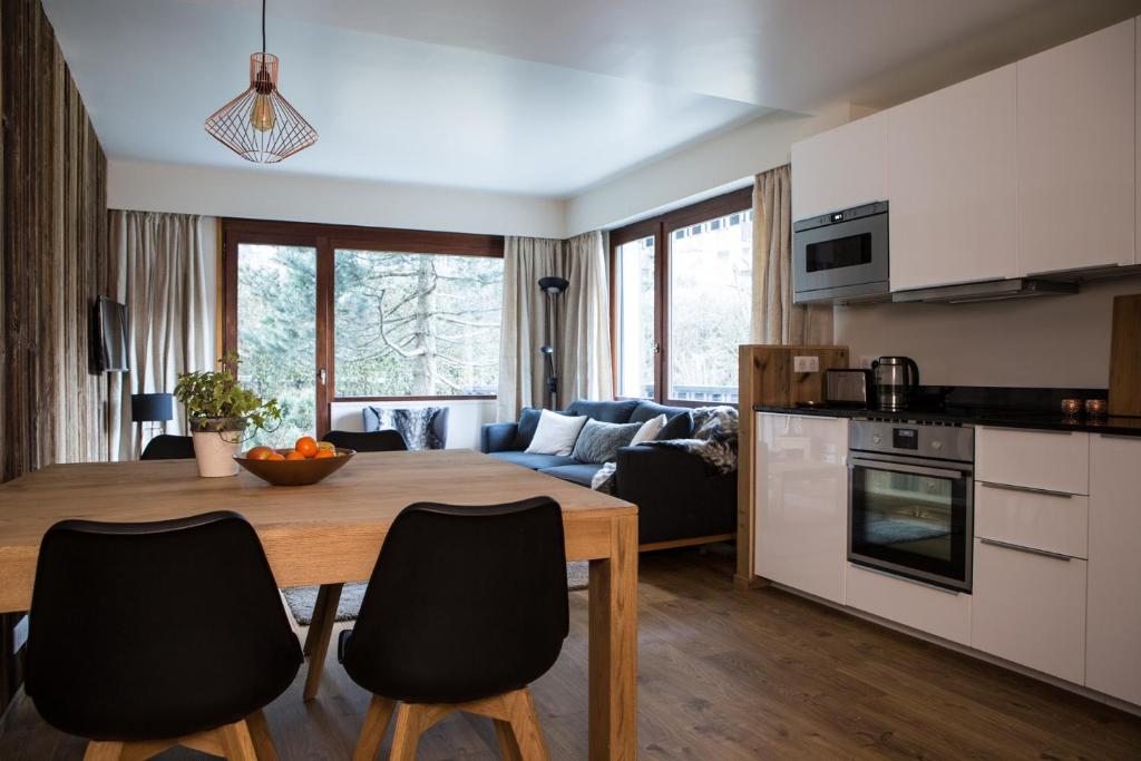 cocina y sala de estar con mesa de madera y sillas en Le Brevent 2 Apartment, en Chamonix-Mont-Blanc