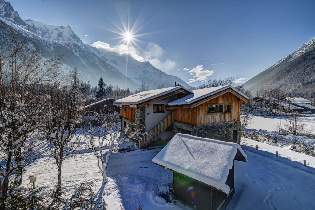 una cabaña en la nieve con montañas en el fondo en Chalet Breitalps, en Chamonix-Mont-Blanc