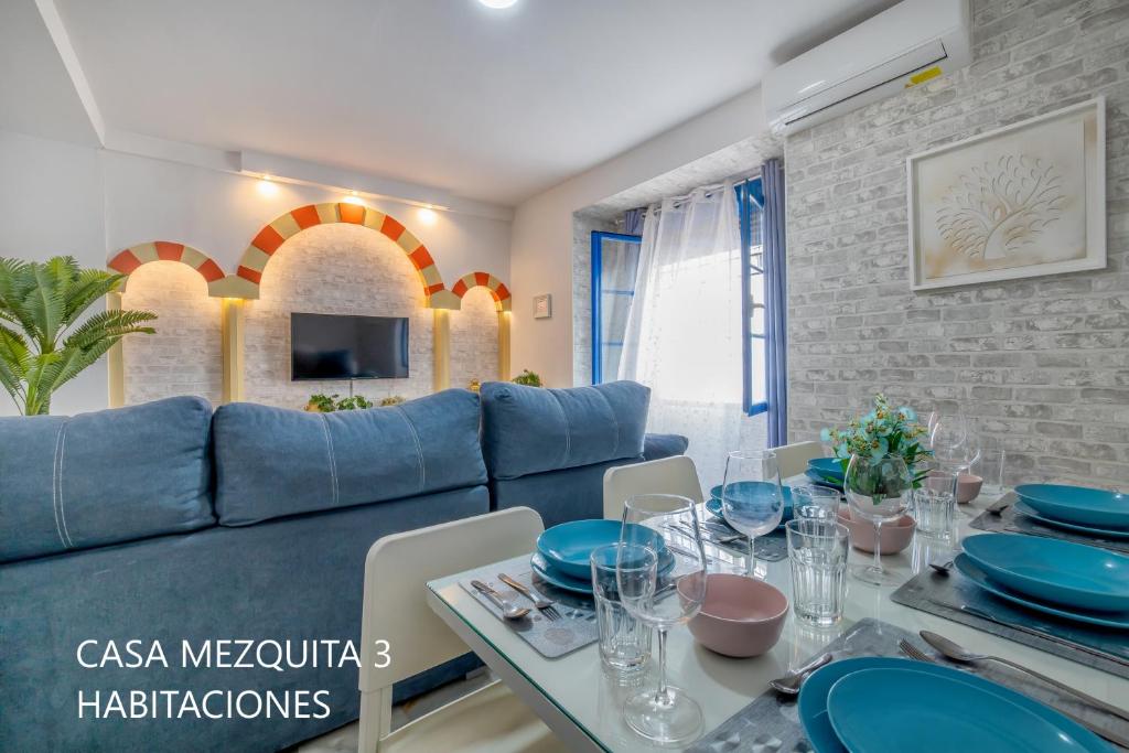 a living room with a blue couch and a table at Casas Caballerizas Mezquita 1 y 3 HAB in Córdoba