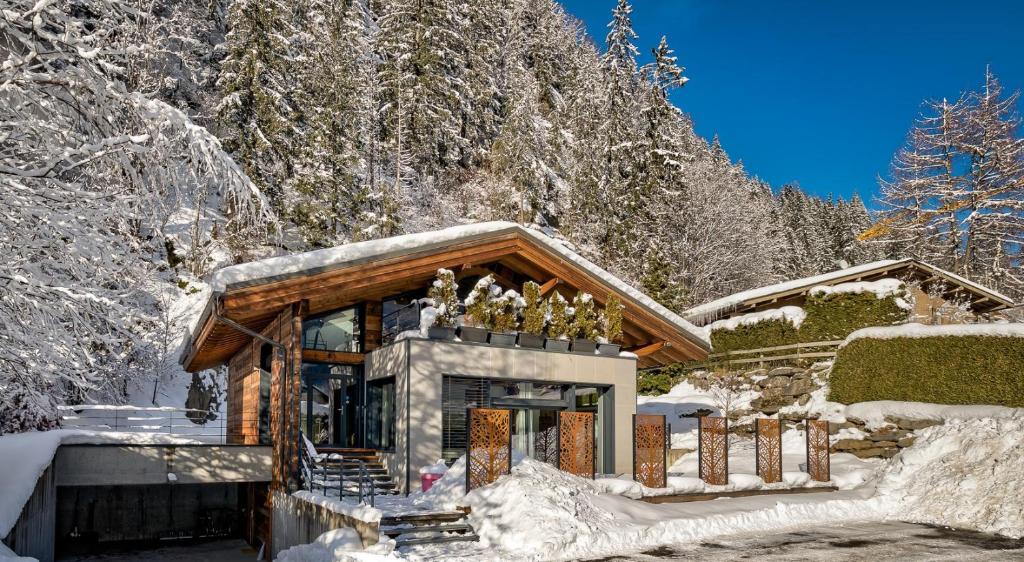 une cabane en rondins dans la neige avec une cheminée dans l'établissement Chalet Belachat, à Chamonix-Mont-Blanc